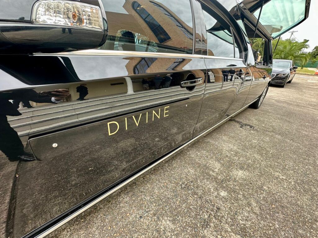 Close-up of Divine Family Funerals' hearse with logo on the door, parked in Sydney