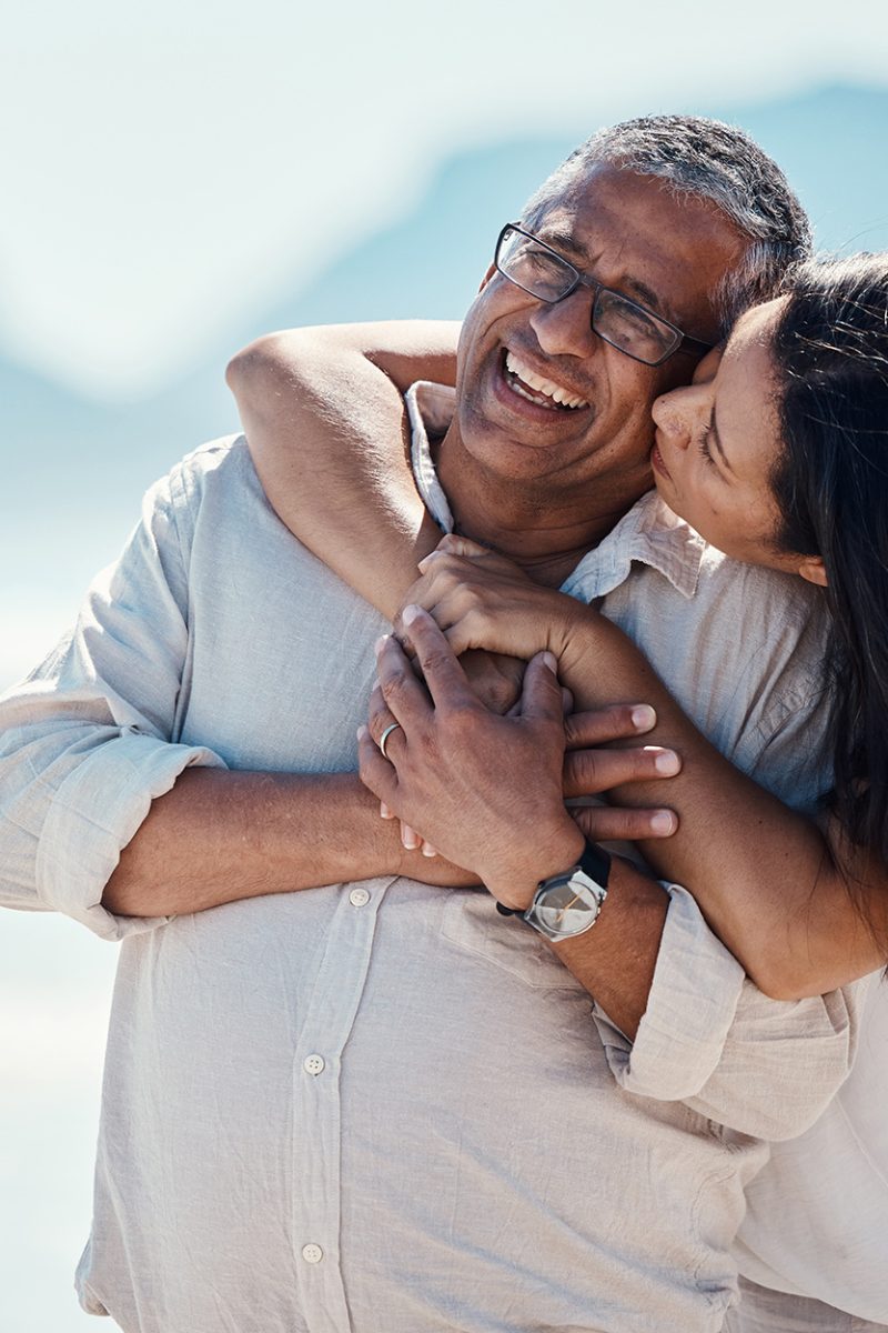 Love, romance and mature couple on beach, embrace and kiss with happy relationship and mockup. Roma.